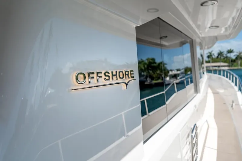 Slide: The Image of 2027 Offshore Yachts 70 CE, sleek design with reflective windows and elegant branding. - 13