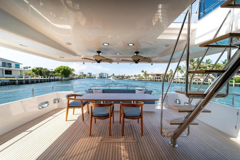 Slide: The Image of Luxurious 2027 Offshore Yachts 70 CE deck with elegant seating and scenic waterfront view. - 8