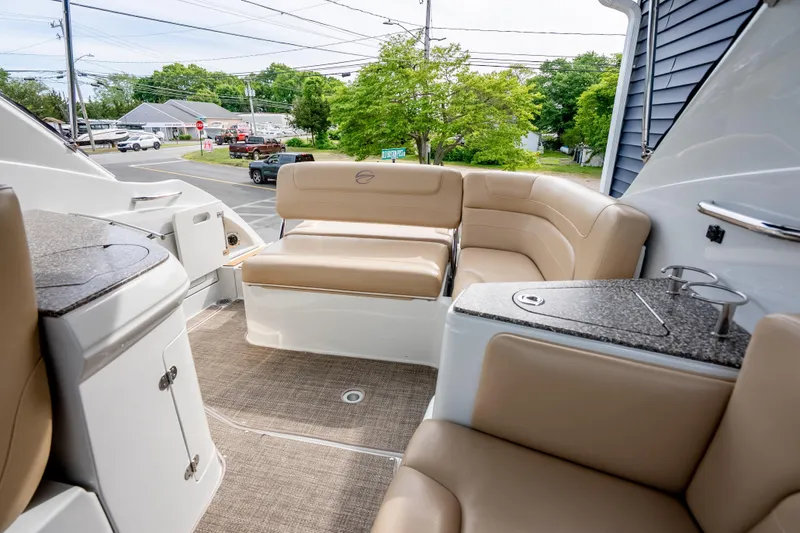 Slide: The Image of 2015 Crownline 294 CR boat interior with beige seating and compact kitchenette. - 9