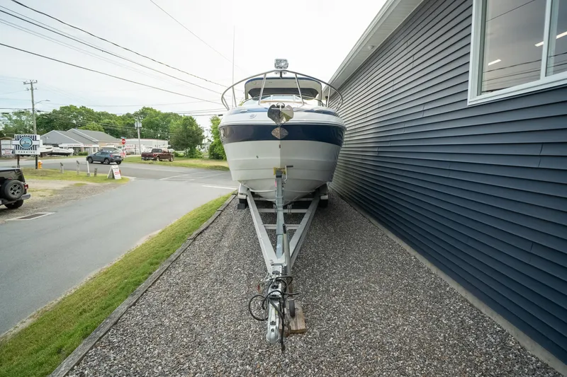 Slide: The Image of 2015 Crownline 294 CR boat on trailer beside a building, ready for transport. - 4