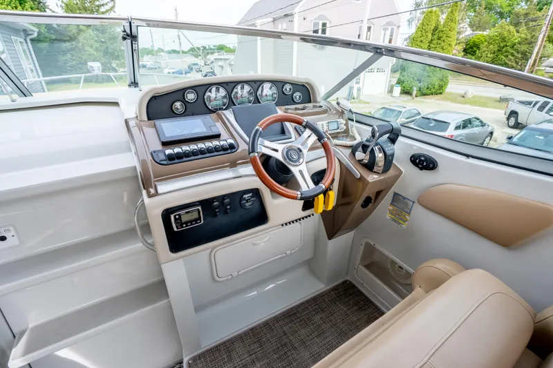 Slide: The Image of 2015 Crownline 294 CR boat helm with modern controls and steering wheel. - 13