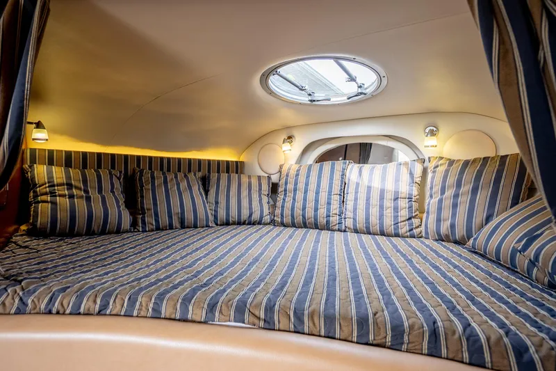 Slide: The Image of Luxurious interior cabin of 2015 Crownline 294 CR boat with striped bedding. - 19