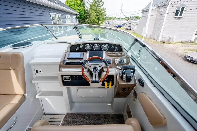 Slide: The Image of 2015 Crownline 294 CR boat cockpit with modern controls and tan seating. - 12