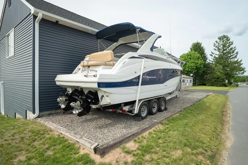 Slide: The Image of 2015 Crownline 294 CR boat on trailer beside a house, ready for transport. - 5