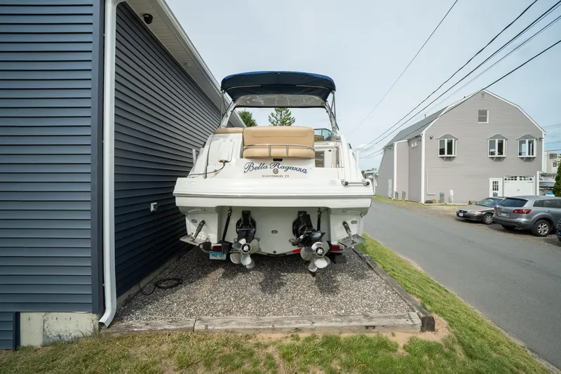 Slide: The Image of 2015 Crownline 294 CR boat parked beside a blue building on a gravel driveway. - 6