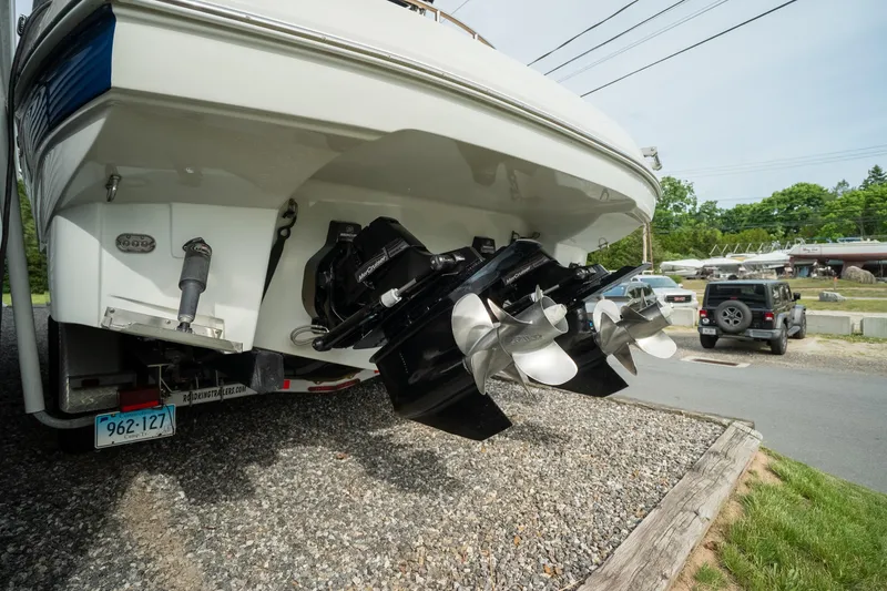 Slide: The Image of 2015 Crownline 294 CR boat with dual propellers on a trailer, parked outdoors. - 7