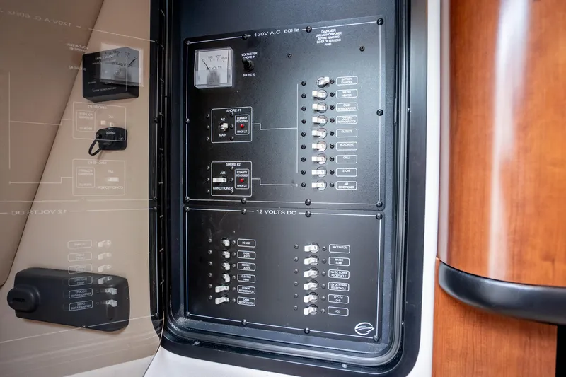 Slide: The Image of Electrical control panel on a 2015 Crownline 294 CR boat, featuring switches and meters. - 25
