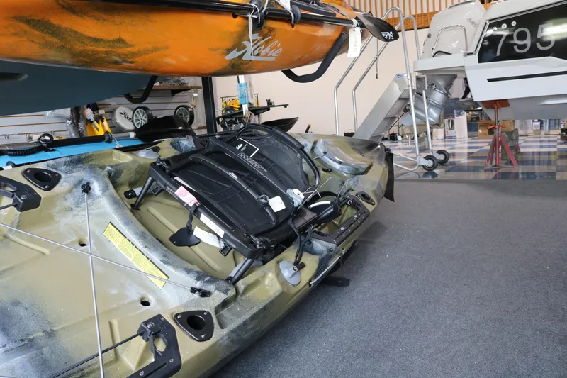 The Image of 2023 Hobie Mirage Outback kayak displayed in a showroom with accessories. - 0