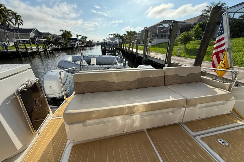 Slide: The Image of Aquila 36 Sport 2019 boat with cushioned seating, docked in a sunny marina. - 16