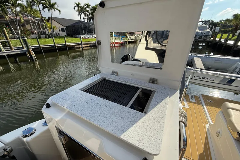 Slide: The Image of Outdoor grill on 2019 Aquila 36 Sport boat, docked by waterfront homes. - 18