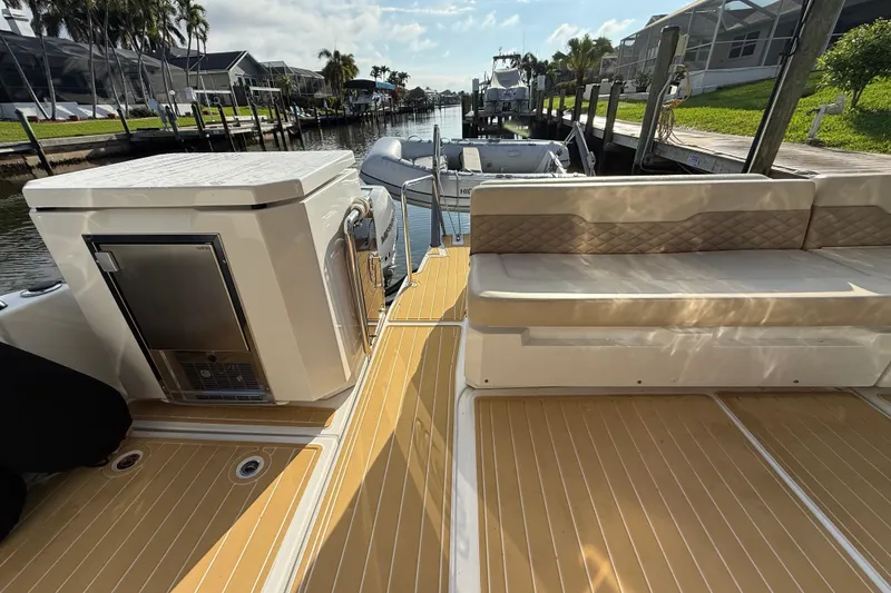 Slide: The Image of 2019 Aquila 36 Sport boat deck with seating and storage, docked by a canal. - 19