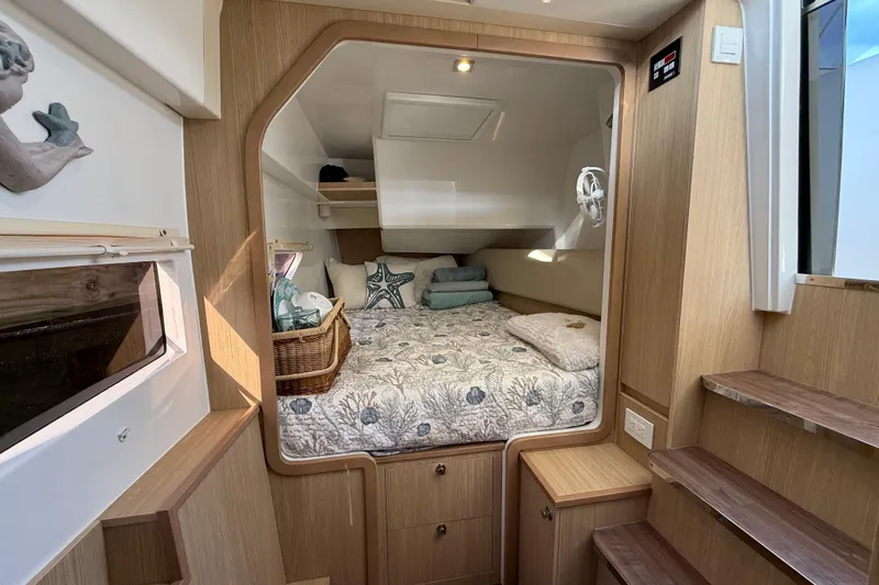 Slide: The Image of Cozy cabin interior of 2019 Aquila 36 Sport with nautical-themed bedding and wooden accents. - 32