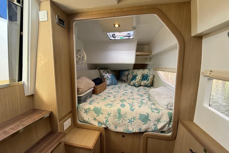Slide: The Image of Cozy cabin interior of 2019 Aquila 36 Sport with nautical-themed bedding and wooden accents. - 37