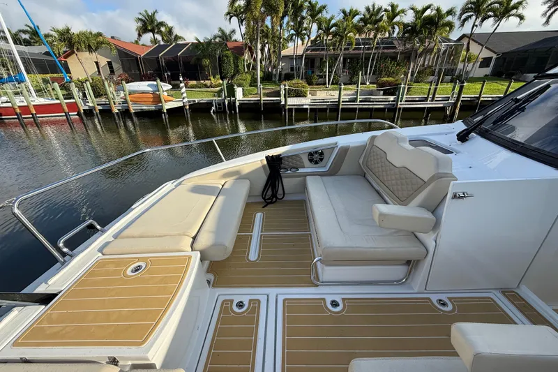 Slide: The Image of Aquila 36 Sport 2019 boat deck with seating, docked near waterfront homes. - 41