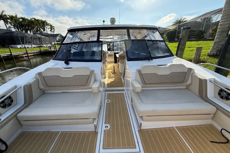 Slide: The Image of 2019 Aquila 36 Sport boat with spacious seating and sleek design, docked by lush greenery. - 43