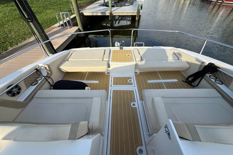 Slide: The Image of 2019 Aquila 36 Sport boat interior with cushioned seating and teak flooring by the dock. - 44
