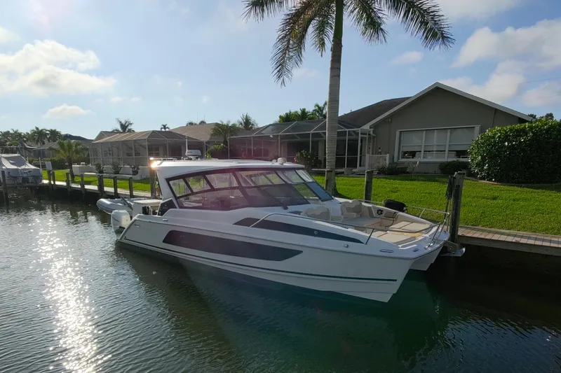 Slide: The Image of 2019 Aquila 36 Sport boat docked by waterfront home under palm tree. - 5