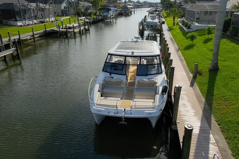 Slide: The Image of 2019 Aquila 36 Sport yacht docked in a serene canal setting. - 8