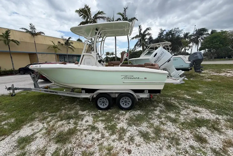 The Image of 2023 Pioneer 202 Islander boat on trailer, parked outdoors with palm trees in background. - 0