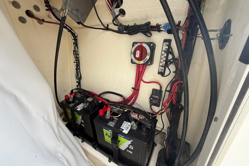 Slide: The Image of Battery compartment of 2023 Pioneer 202 Islander boat with wiring and switches. - 10