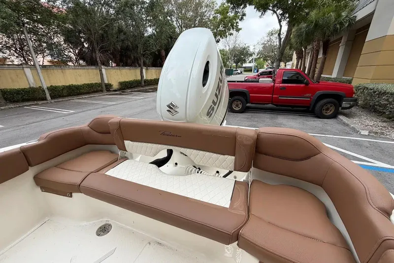 Slide: The Image of 2023 Pioneer 202 Islander boat interior with Suzuki engine, parked near red truck. - 4