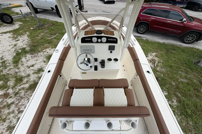 Slide: The Image of 2023 Pioneer 202 Islander boat interior with Garmin navigation, brown and white seating, and steering wheel. - 6