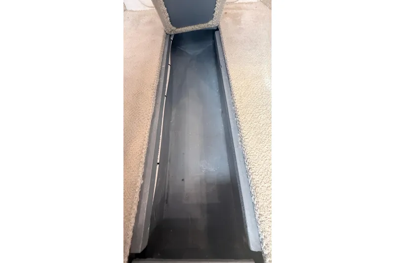 Slide: The Image of Storage compartment in 2004 Sea Ray 340 Sundancer boat, featuring carpeted edges. - 15
