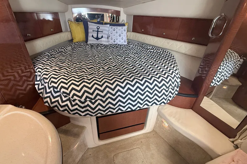Slide: The Image of 2004 Sea Ray 340 Sundancer cabin with chevron bedding and nautical-themed pillows. - 18