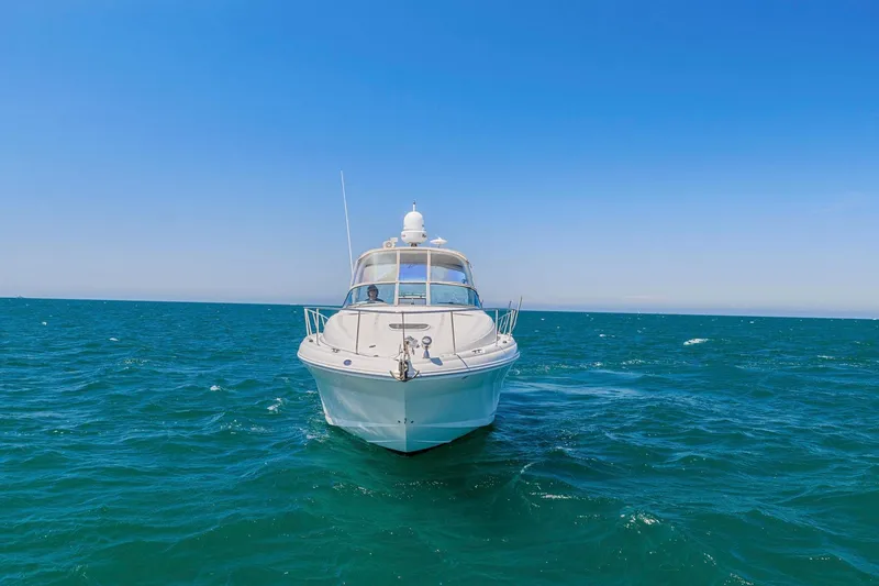 Slide: The Image of 2004 Sea Ray 340 Sundancer yacht cruising on open blue sea under clear sky. - 33