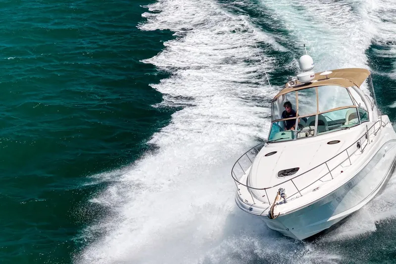 Slide: The Image of 2004 Sea Ray 340 Sundancer cruising on open water, creating a dynamic wake. - 1