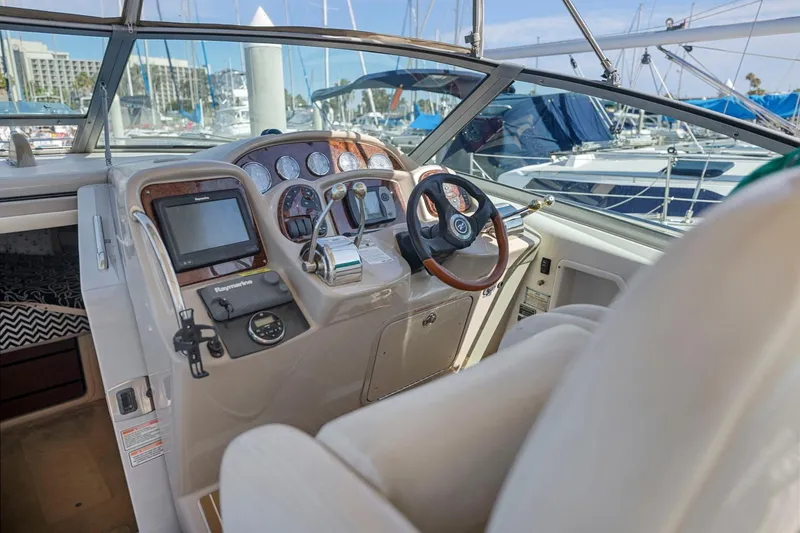 Slide: The Image of 2004 Sea Ray 340 Sundancer helm with steering wheel and navigation instruments. - 13