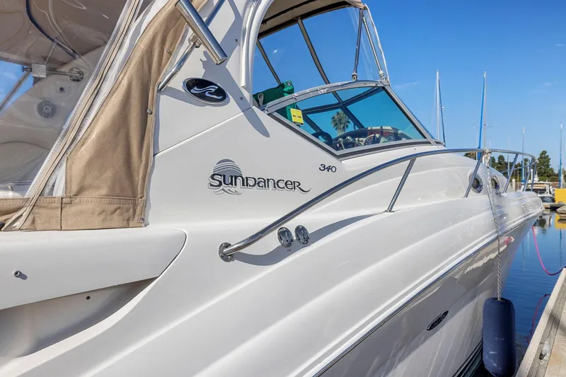 Slide: The Image of 2004 Sea Ray 340 Sundancer yacht docked at marina, showcasing sleek design and branding. - 6