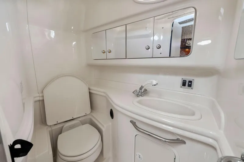 Slide: The Image of Luxurious 2004 Sea Ray 340 Sundancer bathroom with toilet, sink, and mirrored cabinets. - 29