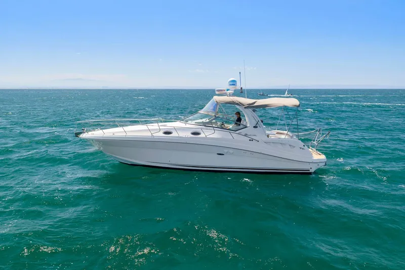 Slide: The Image of 2004 Sea Ray 340 Sundancer yacht cruising on open ocean under clear blue sky. - 41