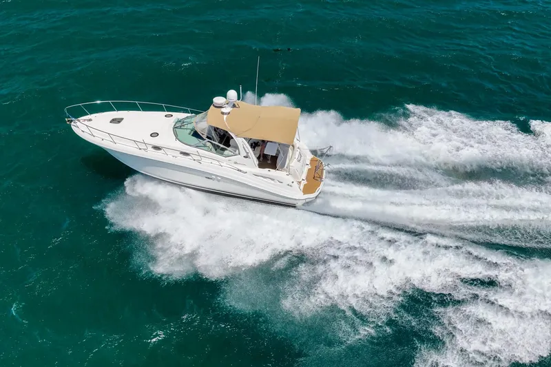 Slide: The Image of 2004 Sea Ray 340 Sundancer cruising on vibrant blue ocean waters. - 49