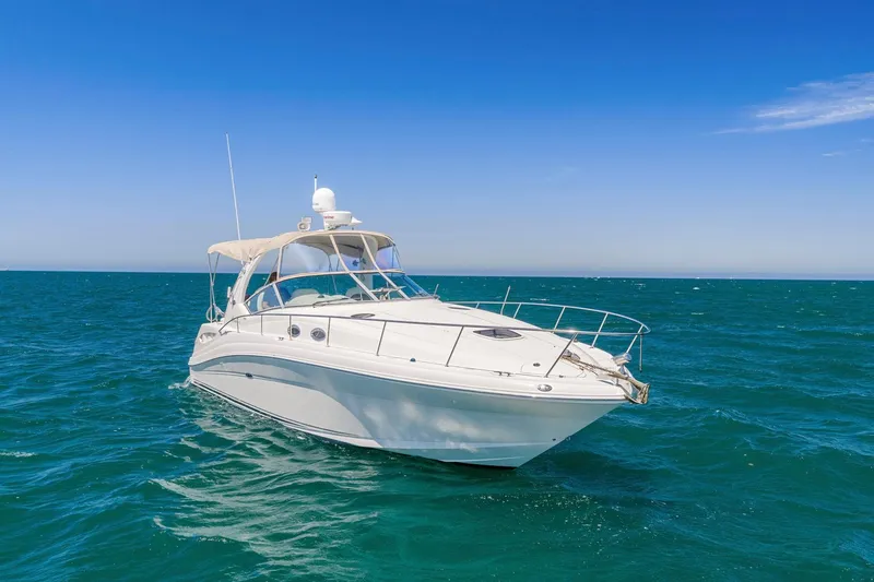 Slide: The Image of 2004 Sea Ray 340 Sundancer yacht cruising on open blue sea under clear sky. - 34