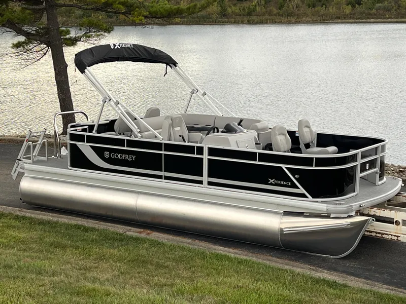 Slide: The Image of 2025 Godfrey Xperience 2086 FX pontoon boat by a serene lake. - 2