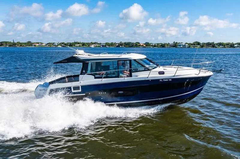 The Image of 2023 Jeanneau NC 1095 cruising on a sunny day, creating waves in the water. - 0