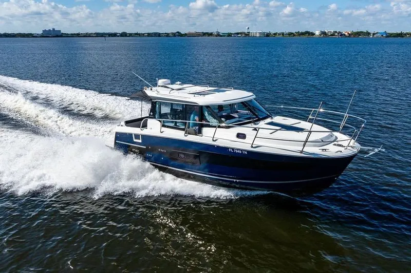 Slide: The Image of 2023 Jeanneau NC 1095 cruising on open water under a clear blue sky. - 10