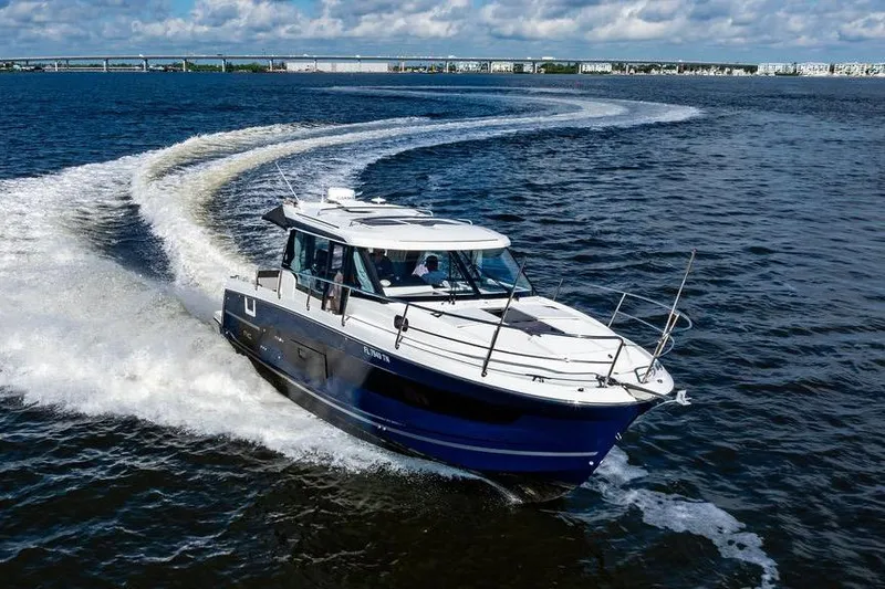 Slide: The Image of 2023 Jeanneau NC 1095 cruising on open water under a partly cloudy sky. - 11