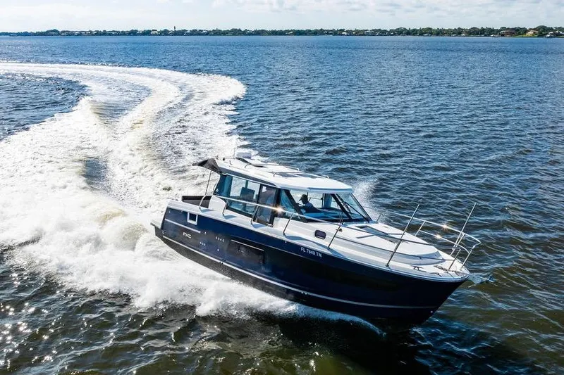 Slide: The Image of 2023 Jeanneau NC 1095 cruising on open water, creating a dynamic wake. - 12