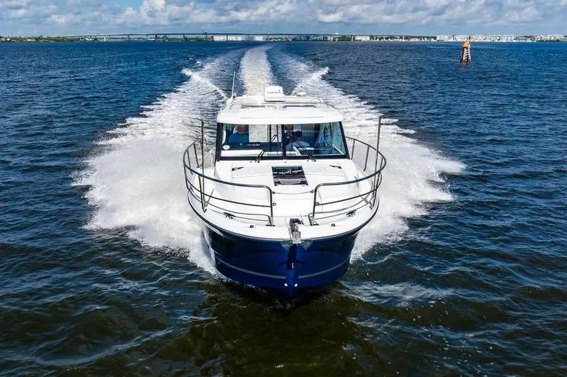 Slide: The Image of 2023 Jeanneau NC 1095 cruising on open water under a partly cloudy sky. - 16