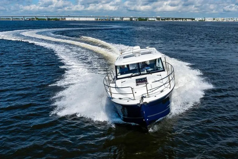 Slide: The Image of 2023 Jeanneau NC 1095 cruising on open water, creating a dynamic wake. - 17