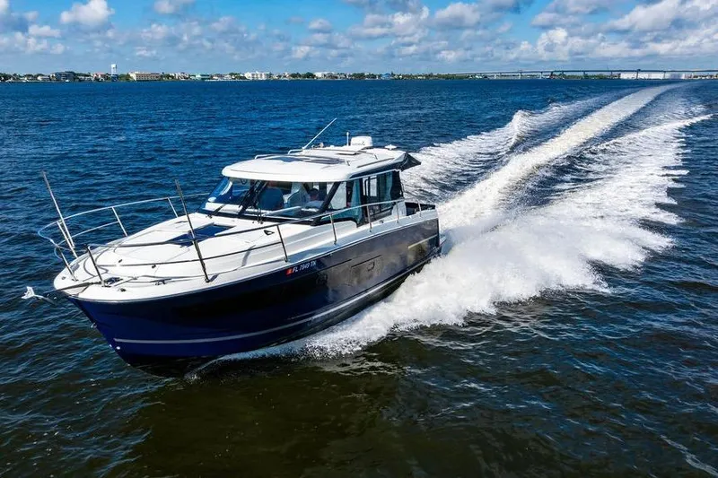 Slide: The Image of 2023 Jeanneau NC 1095 cruising on open water under a clear blue sky. - 19