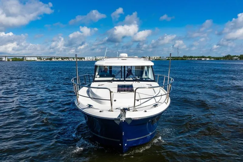 Slide: The Image of 2023 Jeanneau NC 1095 boat cruising on open water under a blue sky. - 2
