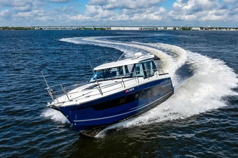 Slide: The Image of 2023 Jeanneau NC 1095 cruising on open water under a partly cloudy sky. - 21
