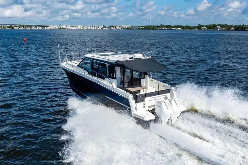 Slide: The Image of 2023 Jeanneau NC 1095 motorboat cruising on open water under a clear sky. - 23
