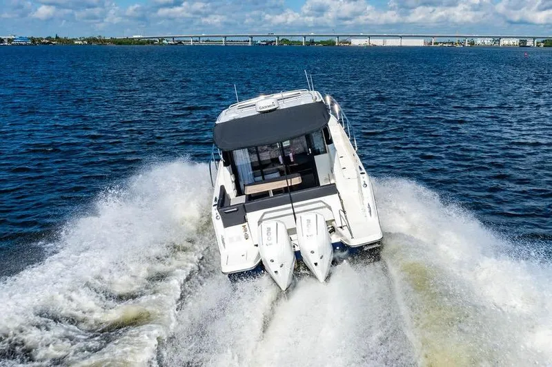 Slide: The Image of 2023 Jeanneau NC 1095 cruising on open water, creating a dynamic wake. - 24