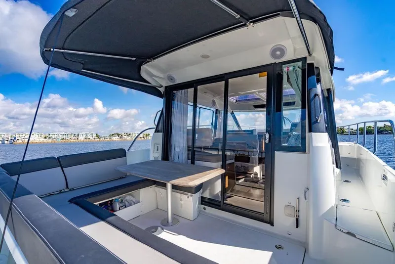 Slide: The Image of 2023 Jeanneau NC 1095 boat interior with seating and table, overlooking water. - 25
