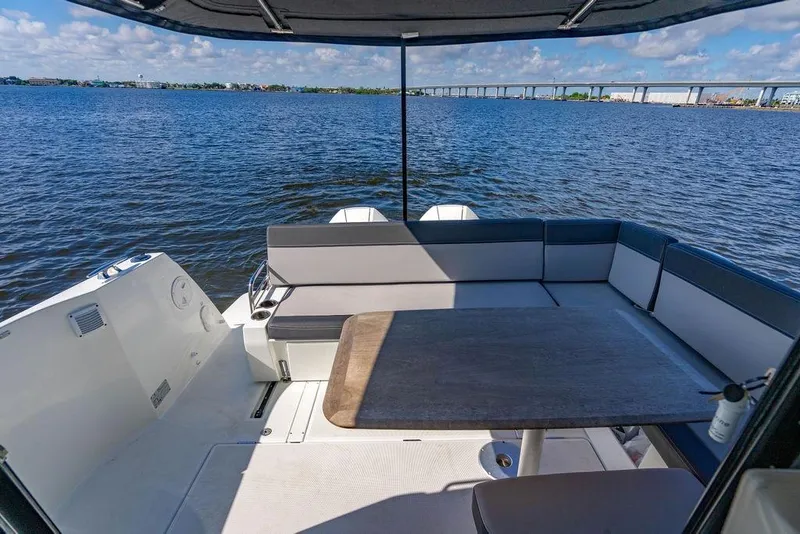 Slide: The Image of 2023 Jeanneau NC 1095 boat deck with seating, table, and scenic water view. - 29